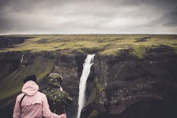 Image - People experiencing a romantic moment in Iceland, wearing raincoats.
