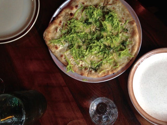 A pizza with a topping of green apples and celery. 