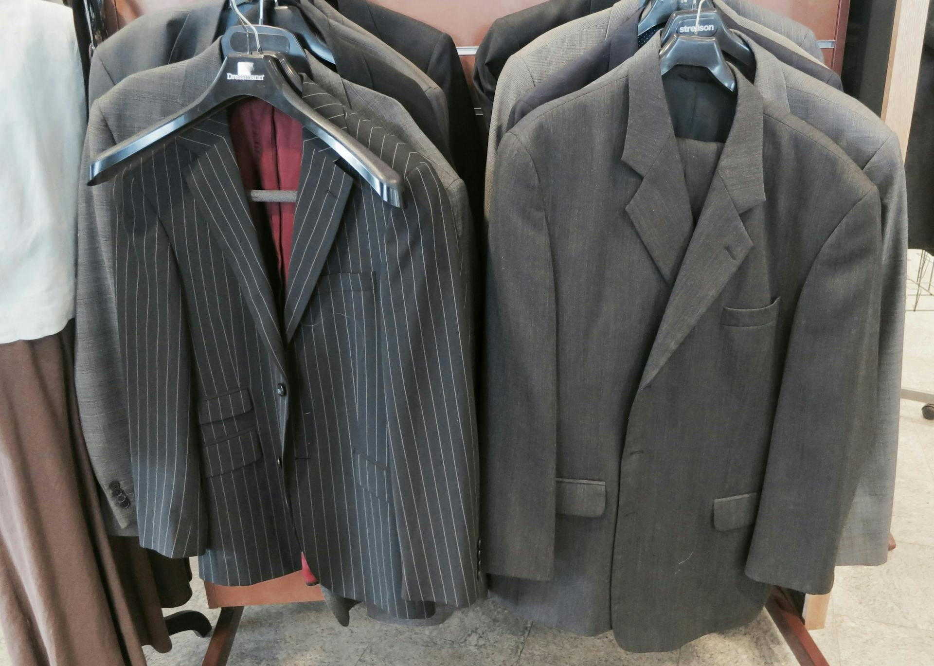 Men's suits hanging on racks in a thrift store in Reykjavik. 