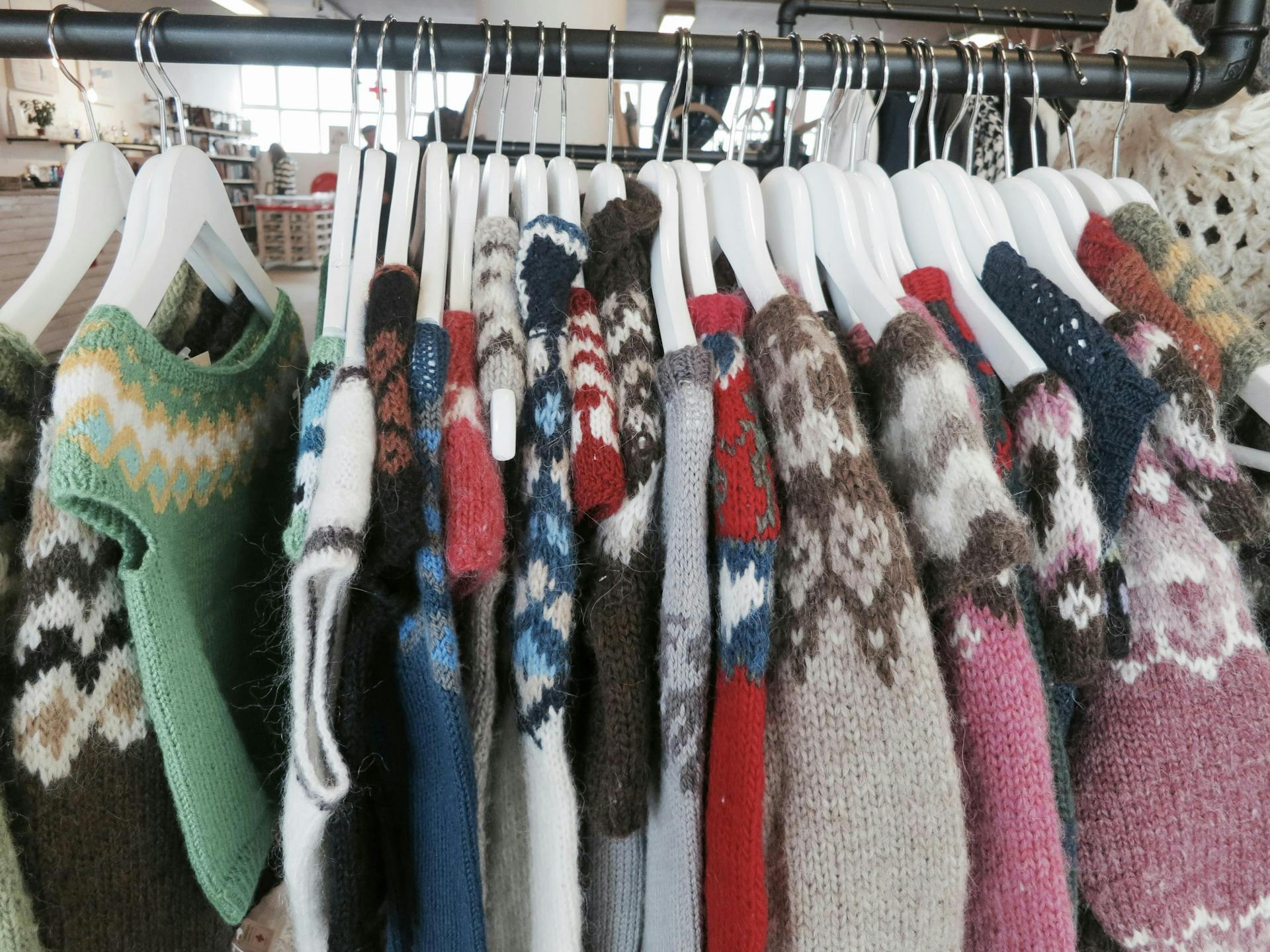 Wool sweaters hanging on a rack. 