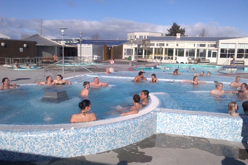 People relaxing in a large hot tub at Sundlaug Vesturbæjar, Reykjavik. 