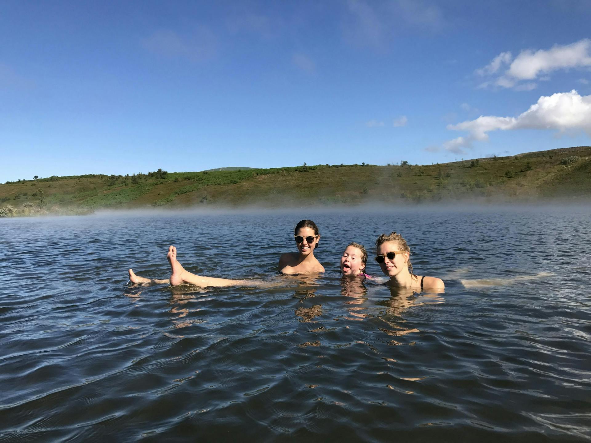 Two women and a child bathing in a geothermal pool. 