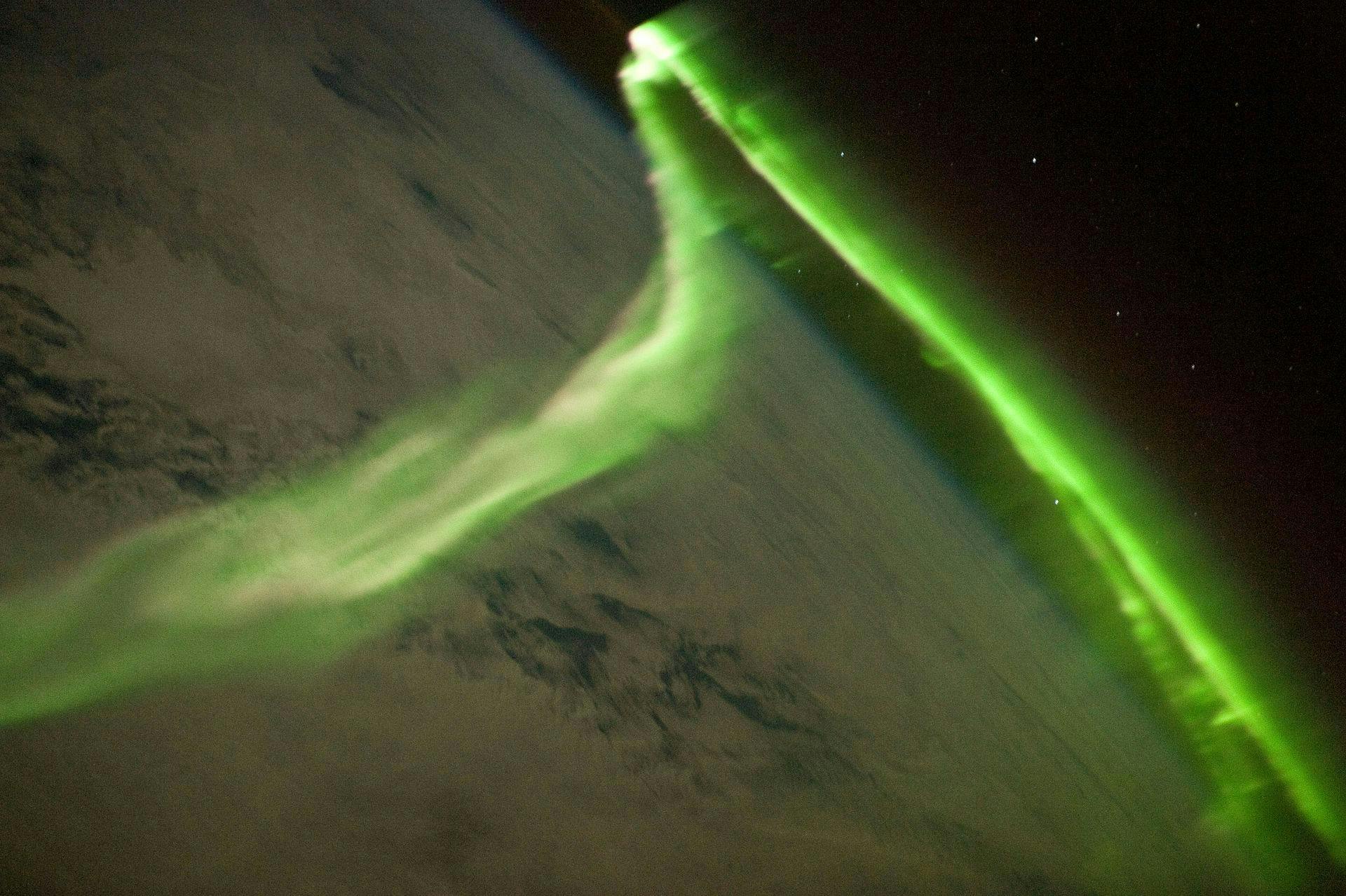 Green aurora taken from space. The Earth below is snowy. 