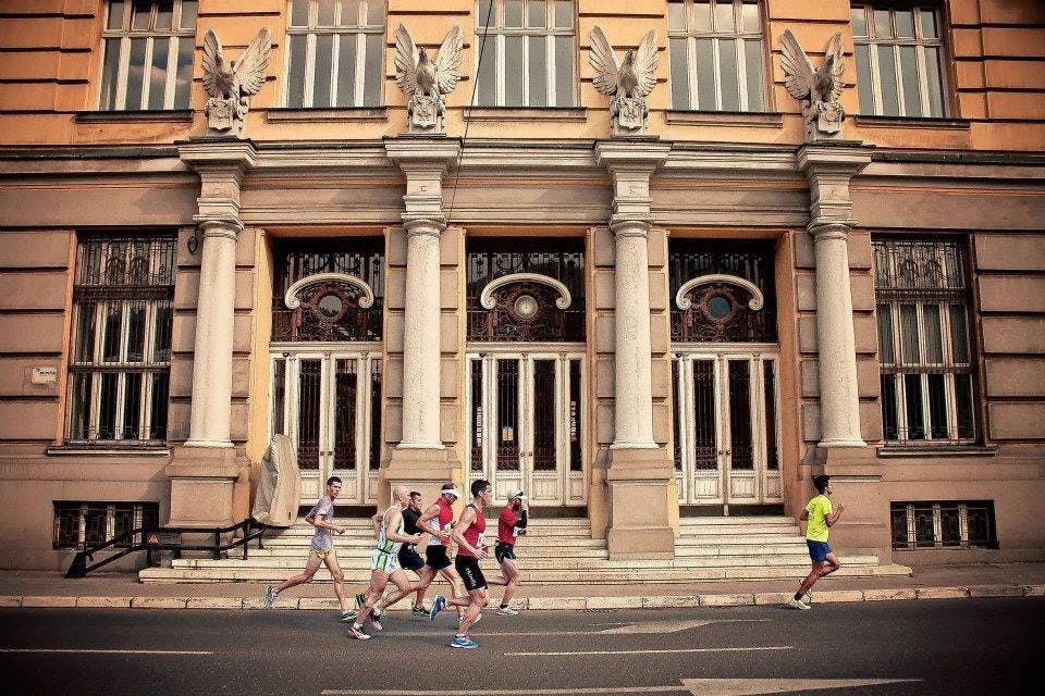 A group of runners passes the post office. 