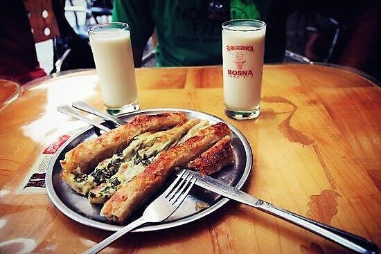 Pastries with spinach on a plate and two glasses of milk. 