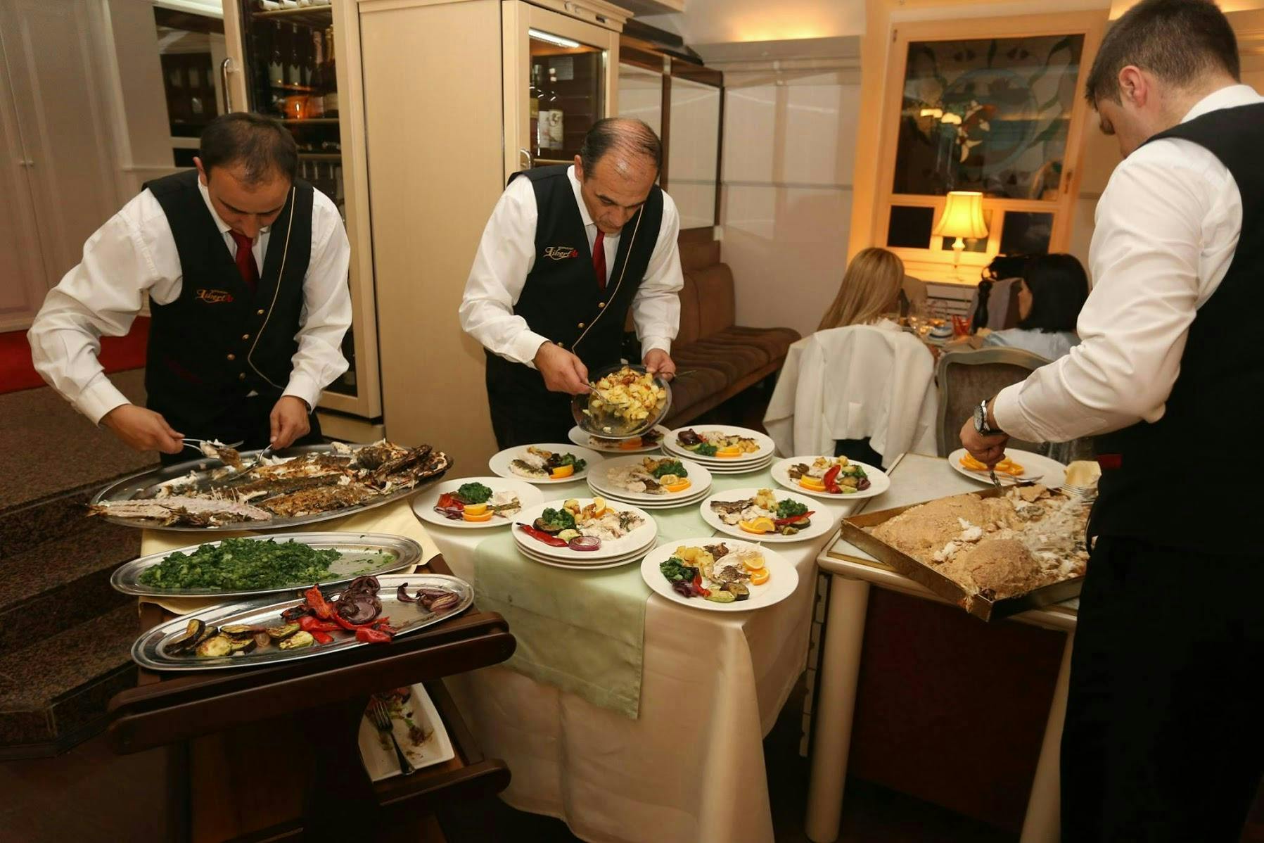 Three waiters preparing food. 