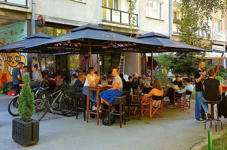 People sitting at an outdoor café on a sunny day. 