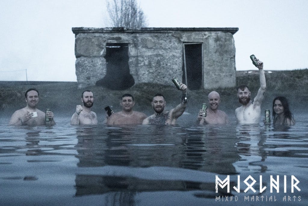 A group of people standing in a geothermal bathing pool. 