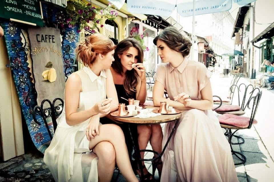 Three women sitting at a pavement café. 