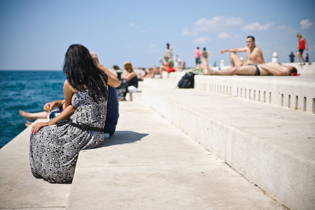 Travelers sitting outside by the Zadar sea organ. 