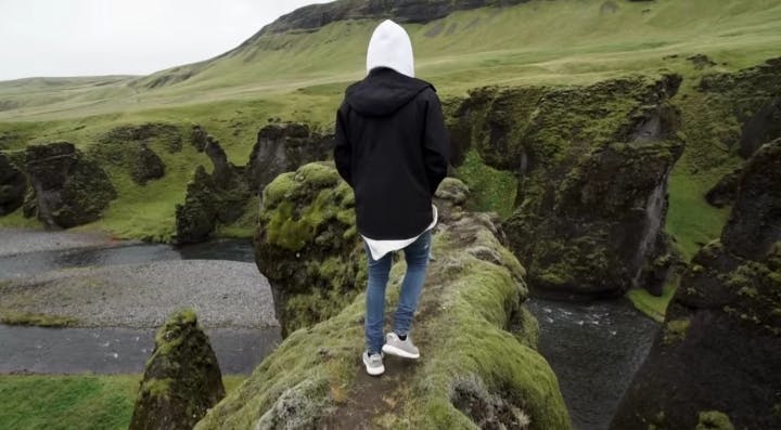 Justin Bieber walking along a ridge in Fjaðrárgljúfur Canyon