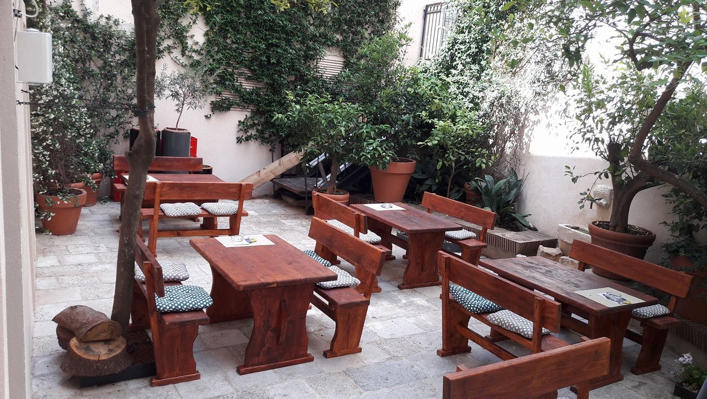 Wooden tables and benches in a courtyard. 