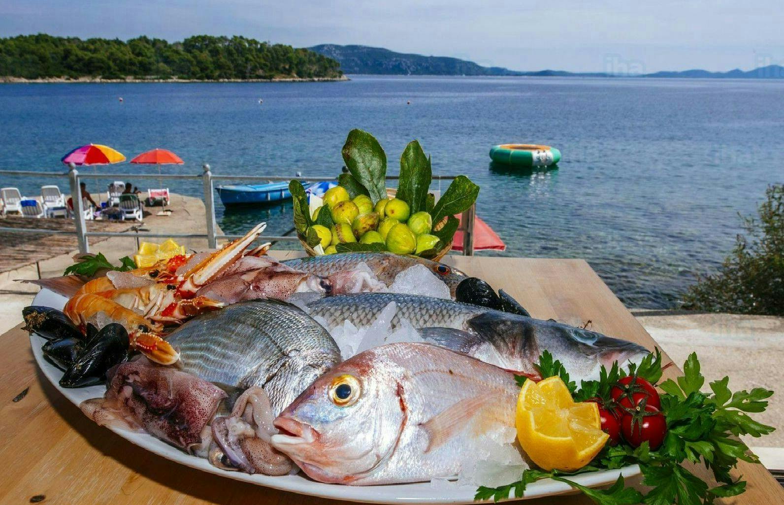 Raw fish on a plate by the beach. 