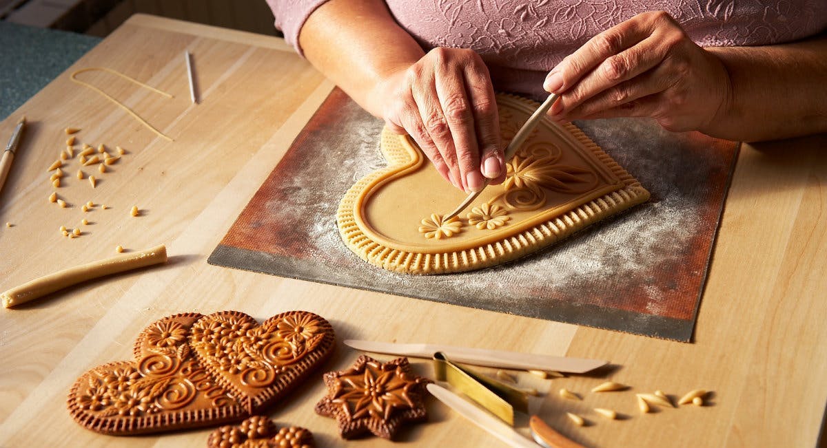 A woman making ornaments for honey biscuits. 