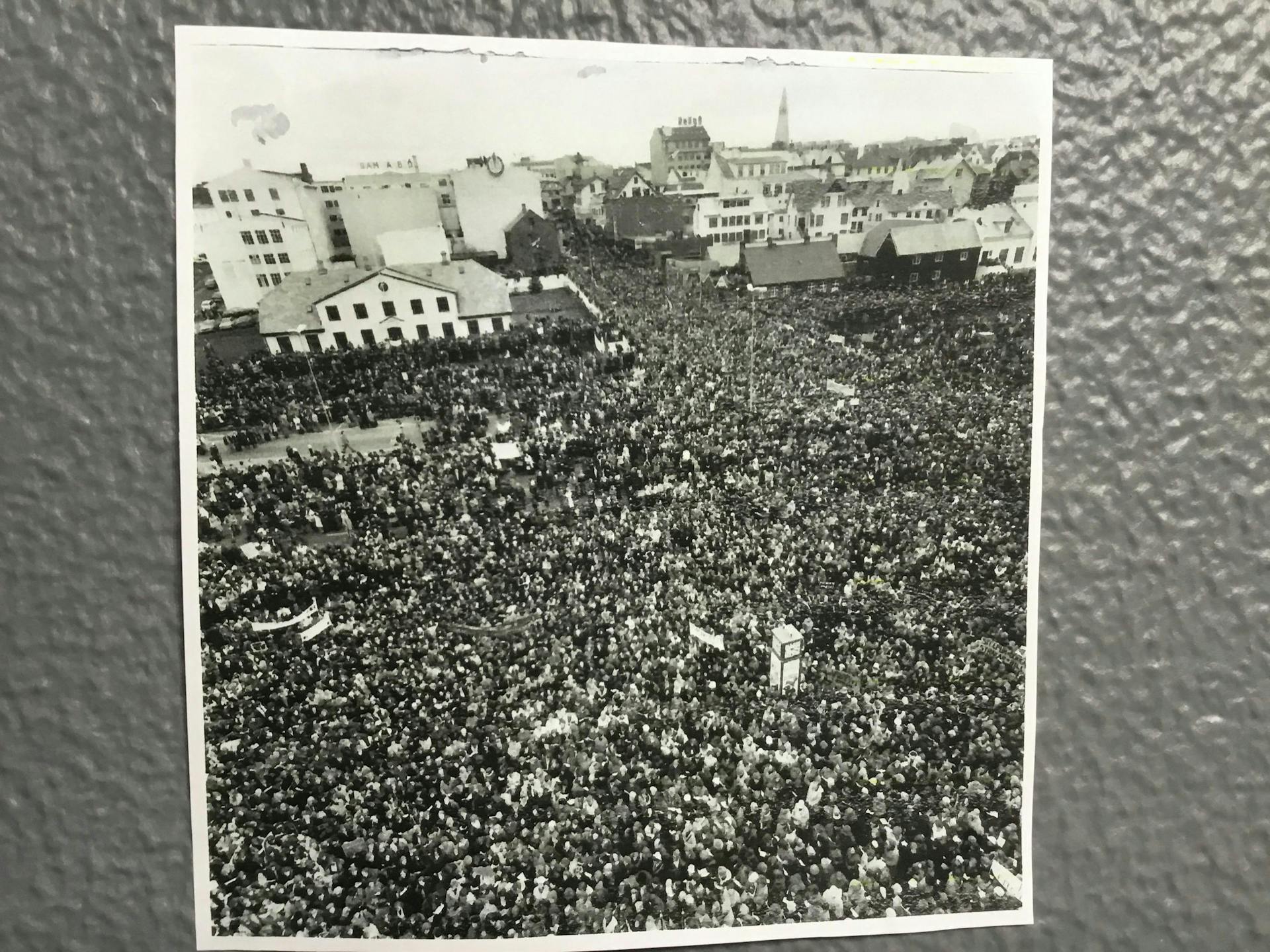 A photograph showing people that have gathered together by the "Stjórnarráð" in Reykjavik. 