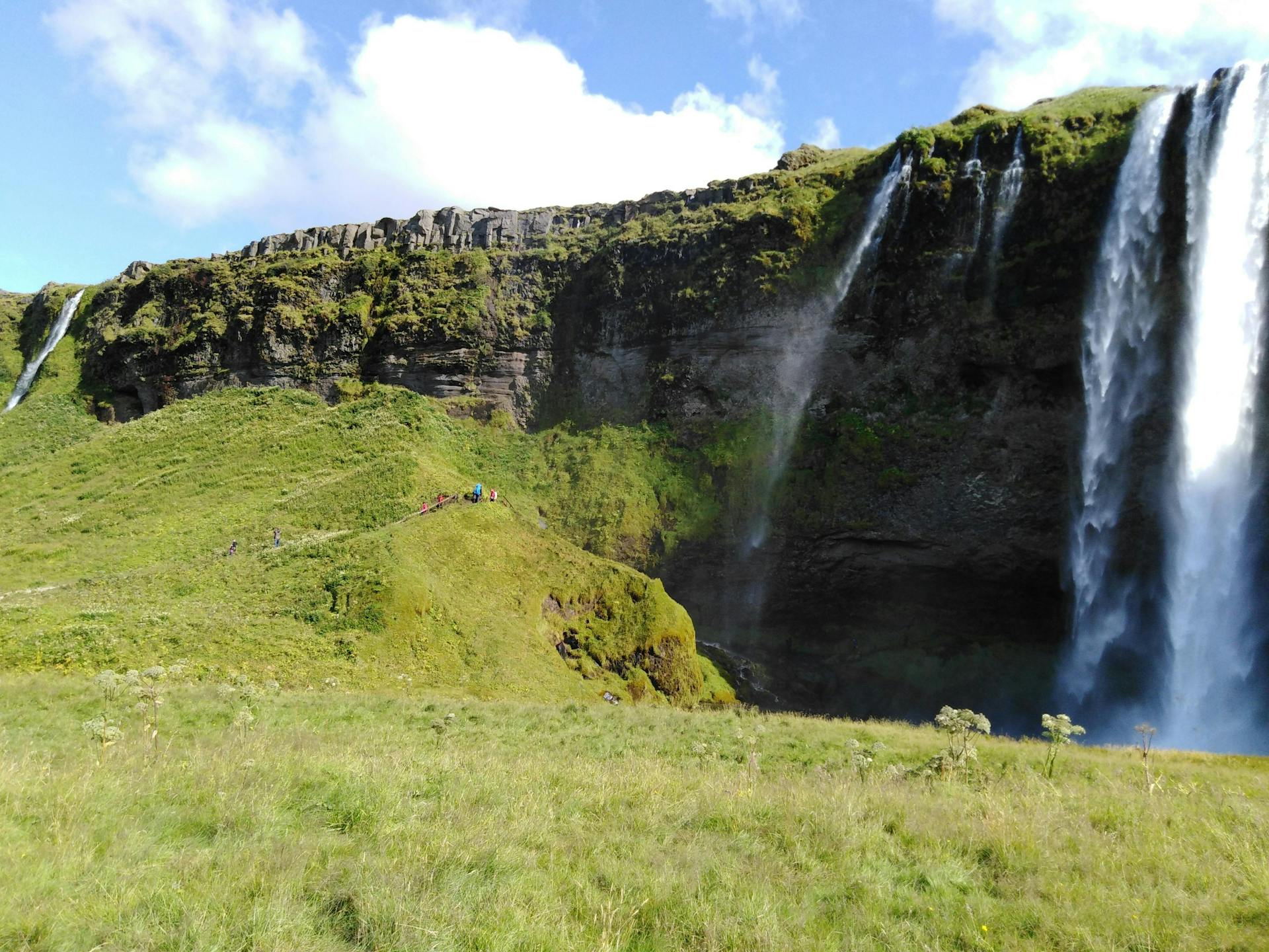 A waterfall and some green fields. 