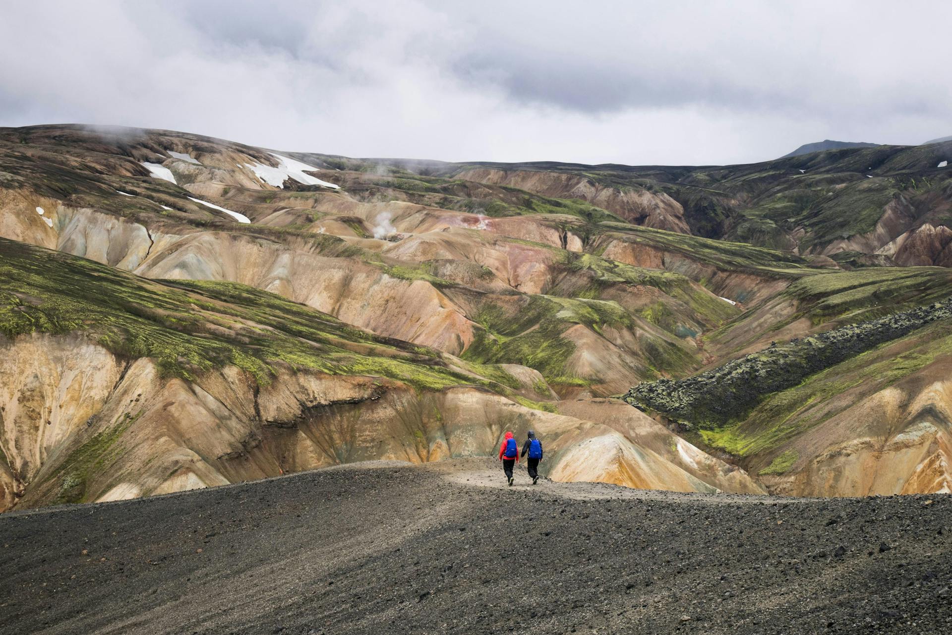 Two persons hiking in rhyolite hills, Icelandic Highlands. 