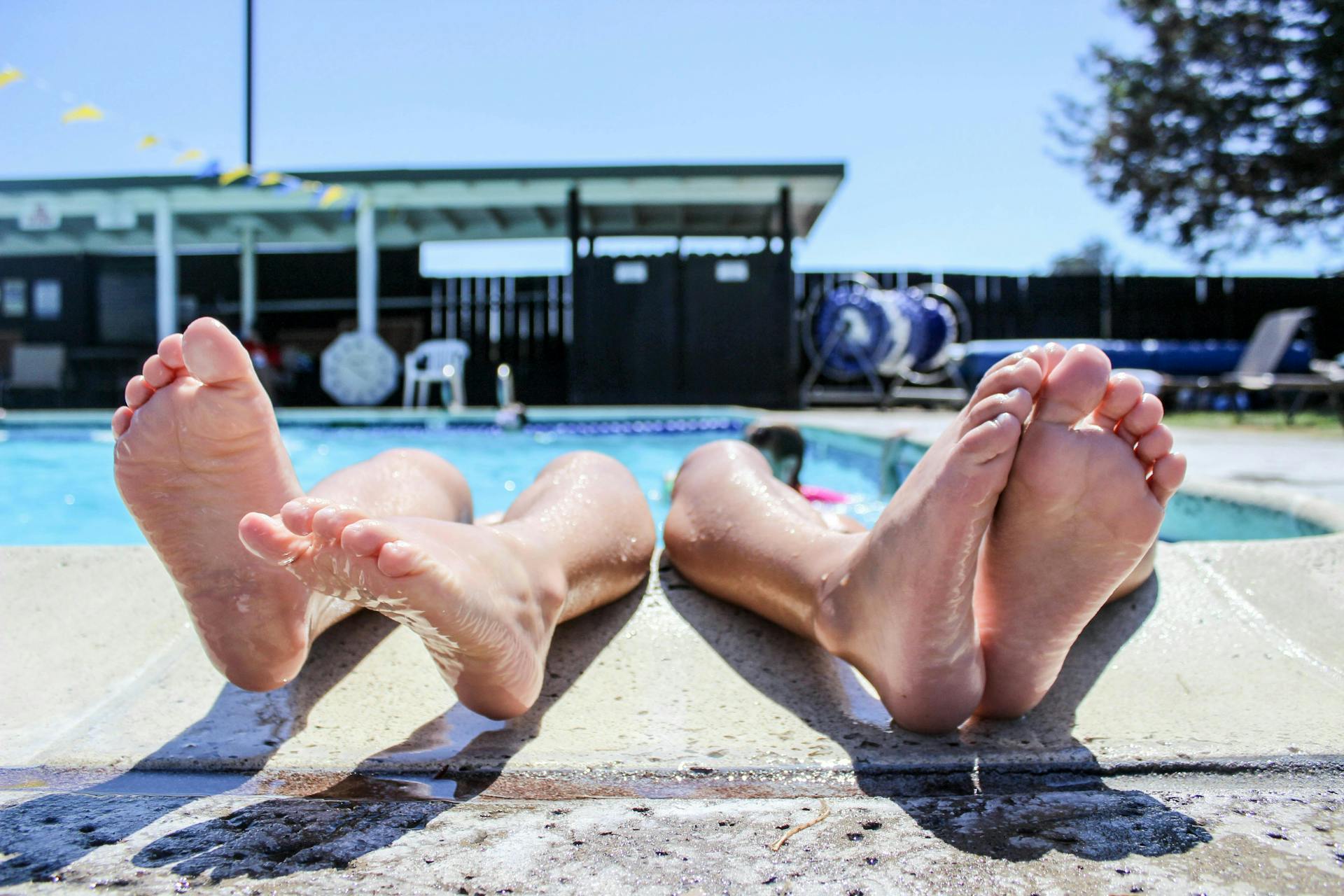 Feet reaching out from a pool, in relaxed position. 