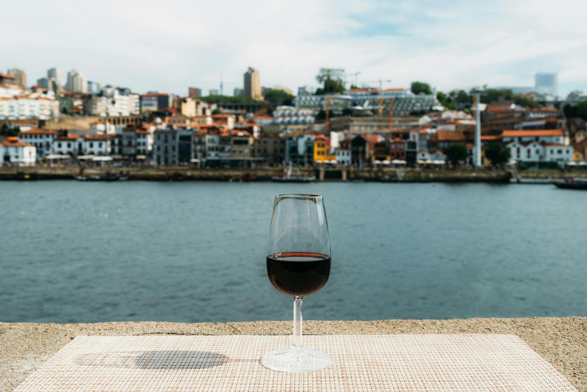 Glass of red Port wine overlooking Vila Nova de Gaia, Porto, Portugal.