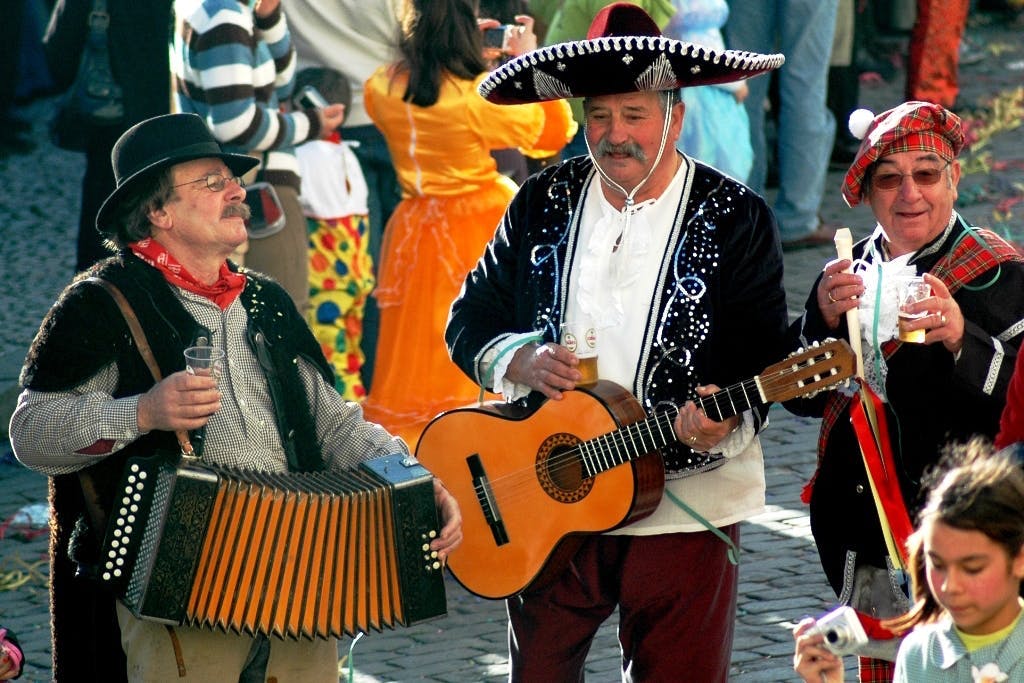 Three Portuguese men playing instruments during Carnaval. 