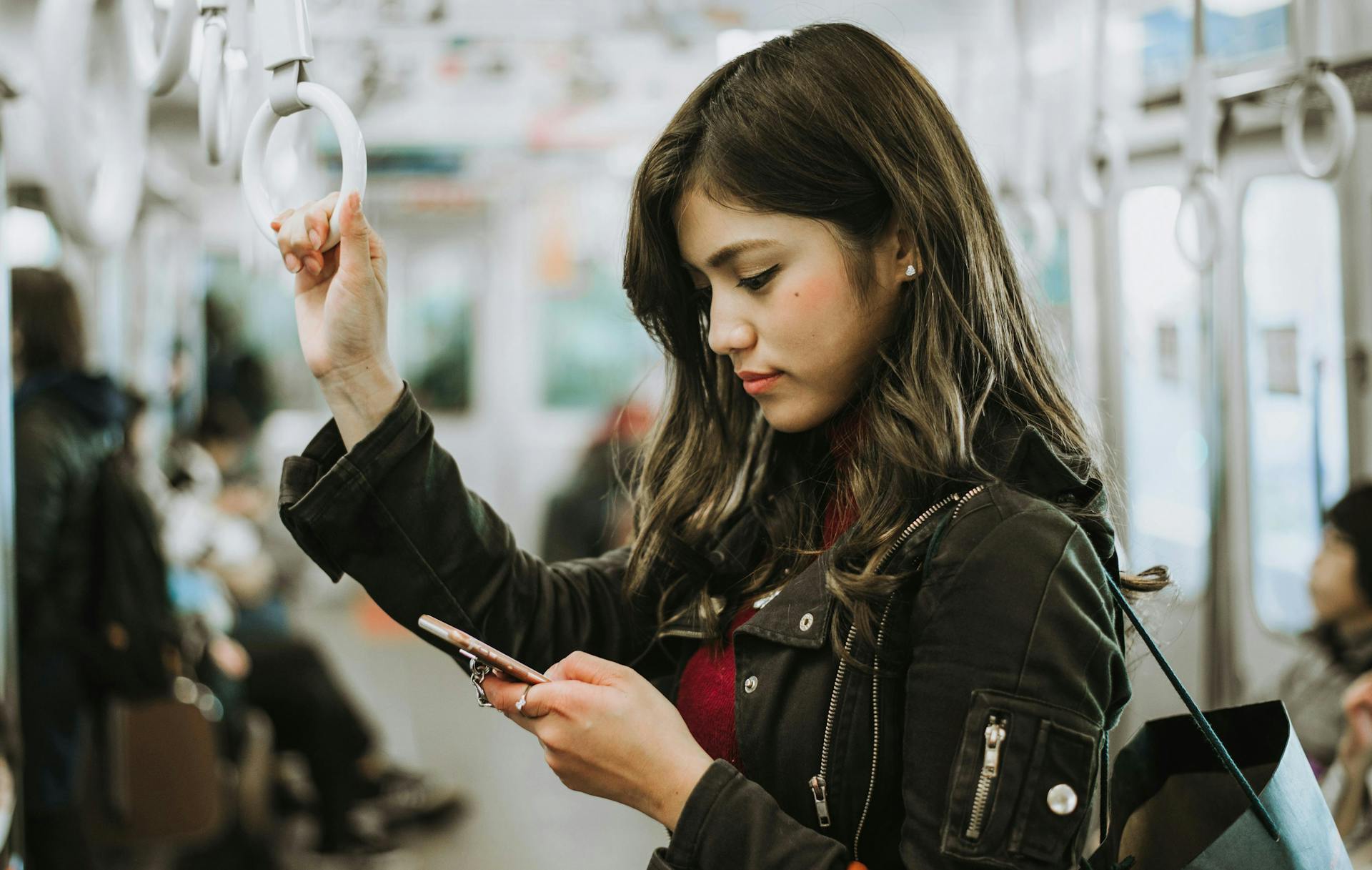 Japanese woman checking her phone in a train in Japan. 