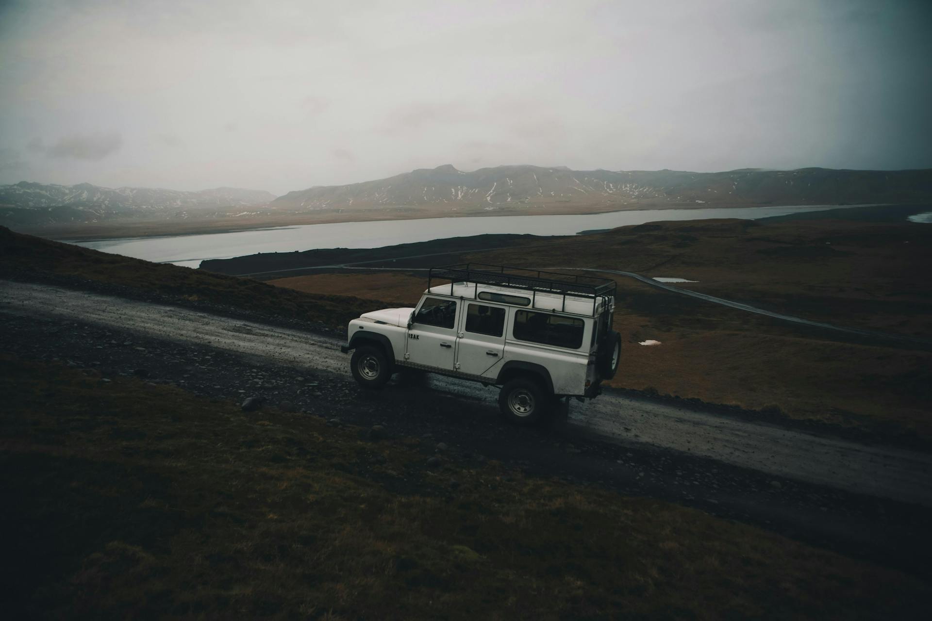 White Land Rover driving in rural Iceland. 